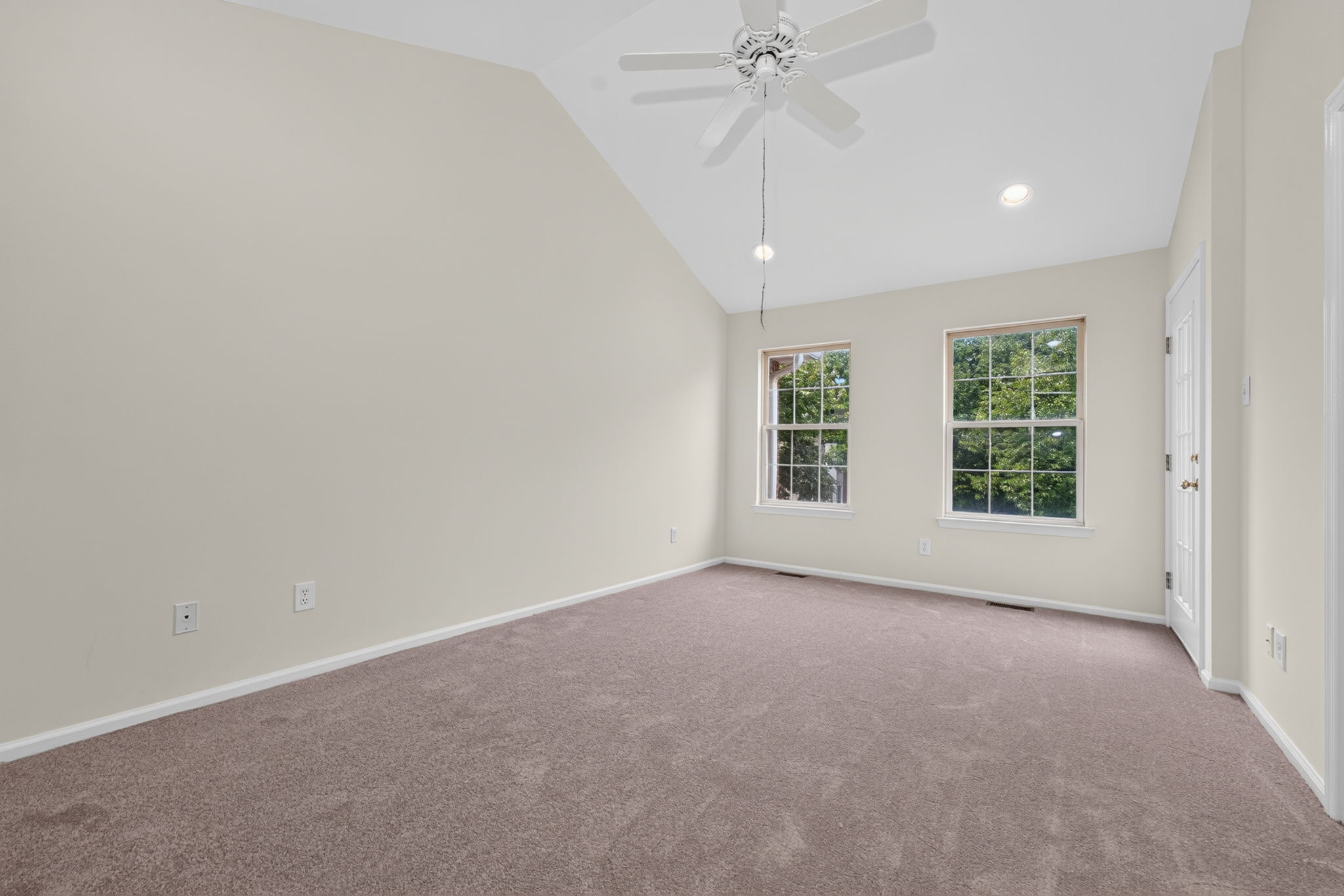 The primary bedroom features a cathedral ceiling, recessed lighting, ceiling fan, walk-in closet, and NEW CARPETING, with direct access to a private deck.