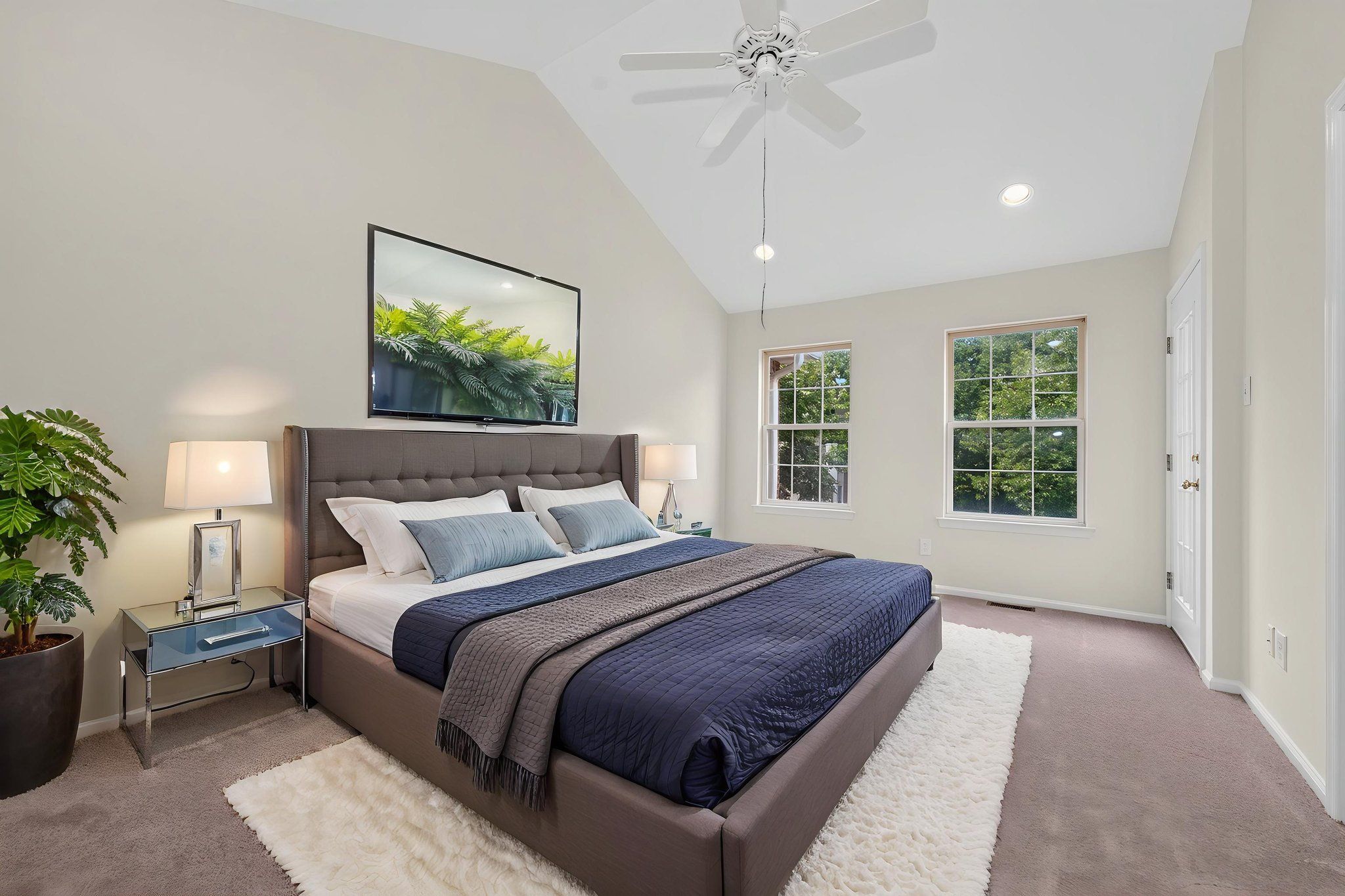 Virtually Staged. The primary bedroom features a cathedral ceiling, recessed lighting, ceiling fan, walk-in closet, and NEW CARPET!ith direct access to a private deck.