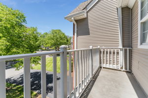 The primary bedroom features a cathedral ceiling, recessed lighting, ceiling fan, walk-in closet, and neutral carpeting, with direct access to a private deck.