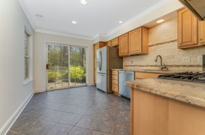 Recessed and under cabinet lighting ensure well-lit workspaces. Stainless steel sink with disposal and gooseneck faucet.