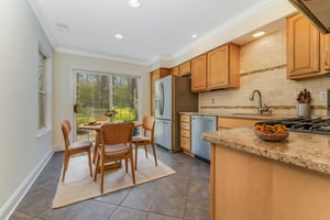 Virtually Staged. The renovated kitchen features raised-panel cabinetry with soft close drawers and pantry, granite counter tops, ceramic tile backsplash, stainless steel appliances, and ceramic tile floor.