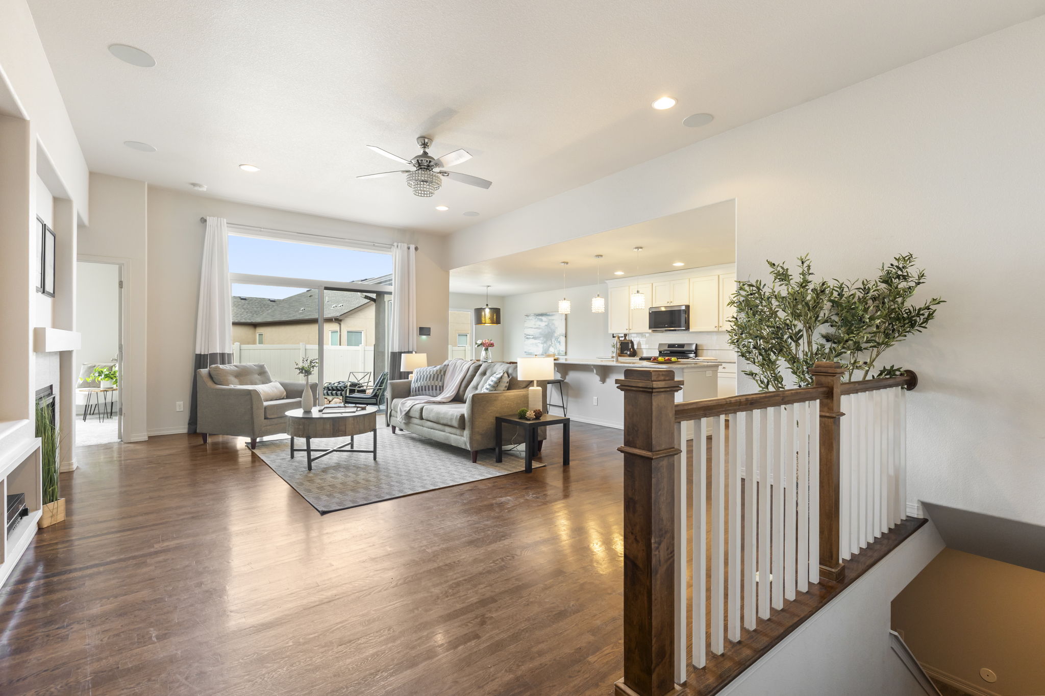 Open-concept great room with gas fireplace, vaulted ceiling, and hardwood floors.