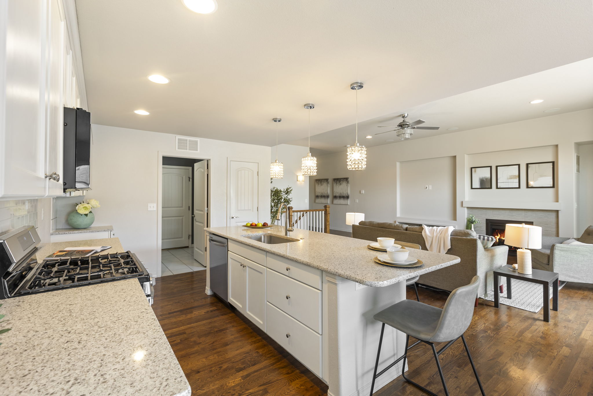 Open kitchen and dining layout showcasing island seating and connection to the great room.