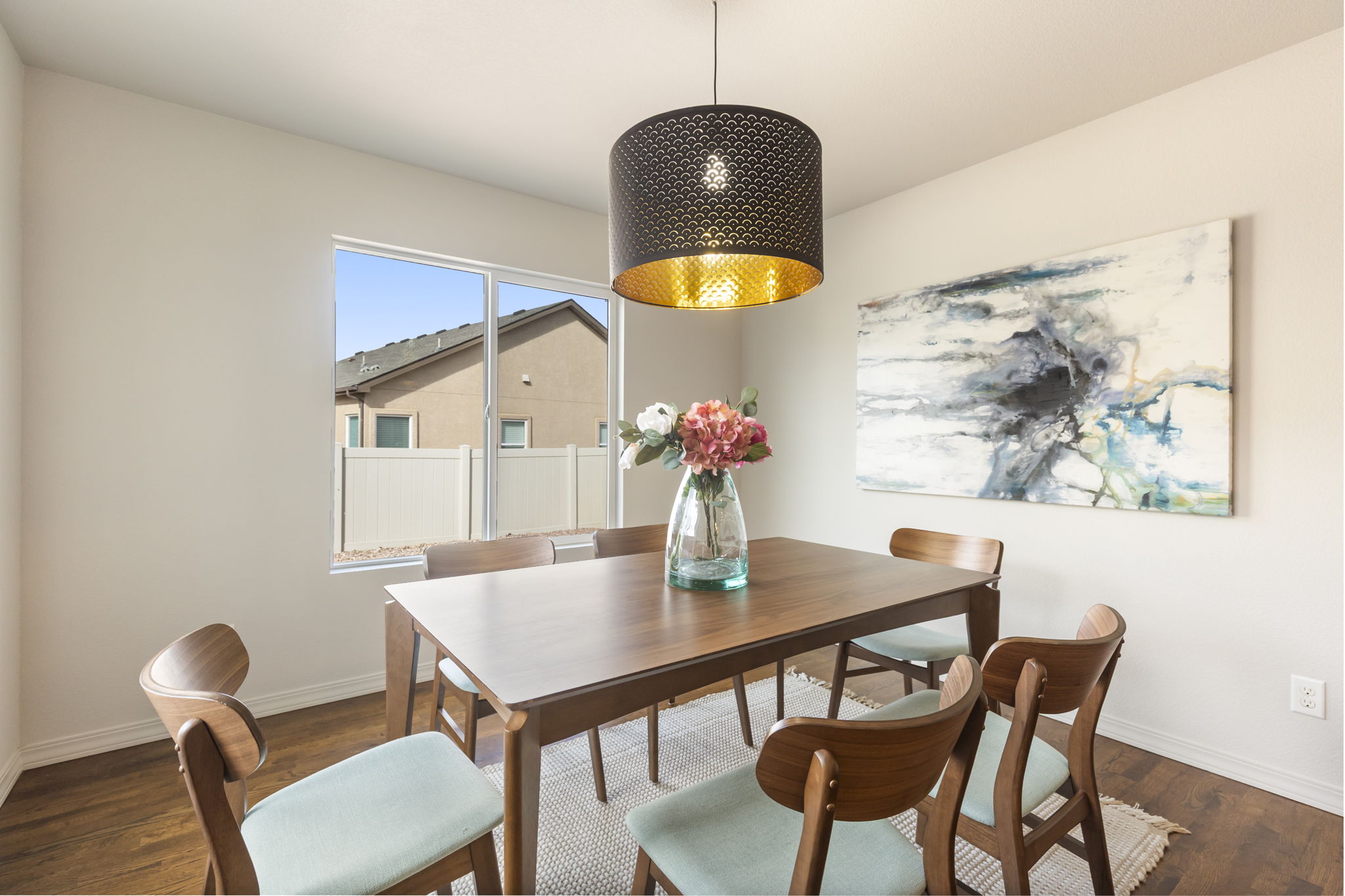 Dining area with modern pendant lighting  overlooking the backyard.