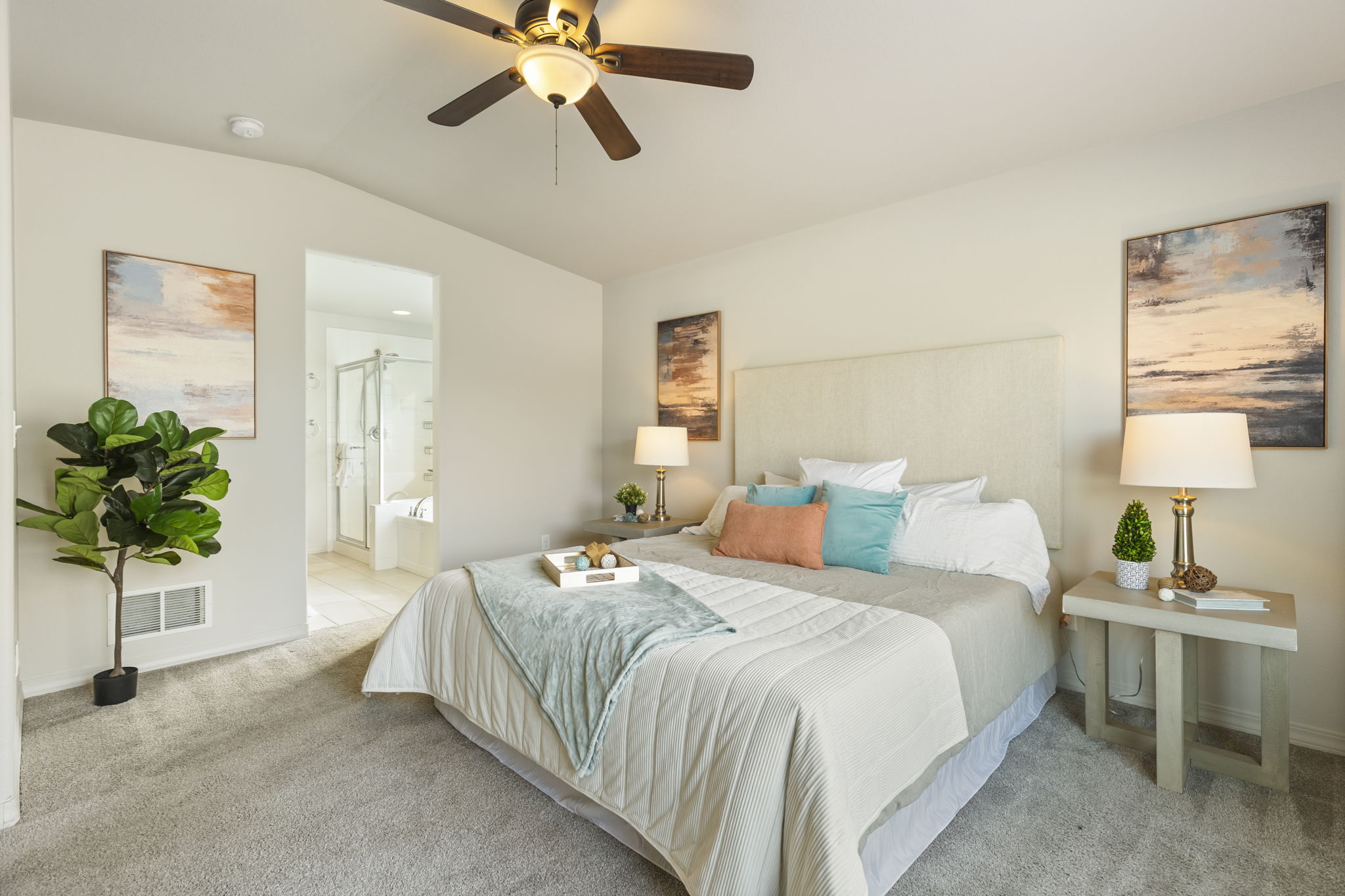Main-level primary bedroom with vaulted ceiling, plush carpet, and ensuite bath access.