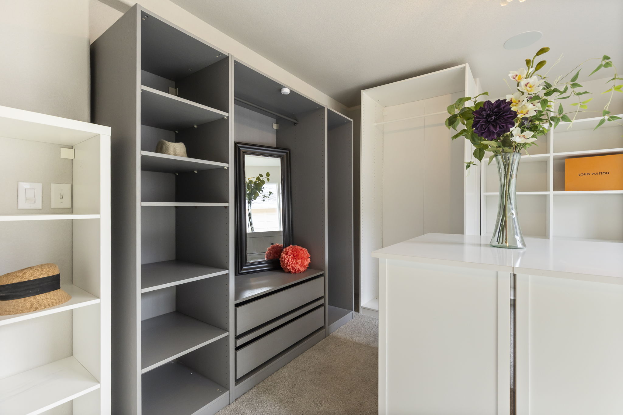 Custom double walk-in closet featuring built-in drawers, shelving, and hanging space.