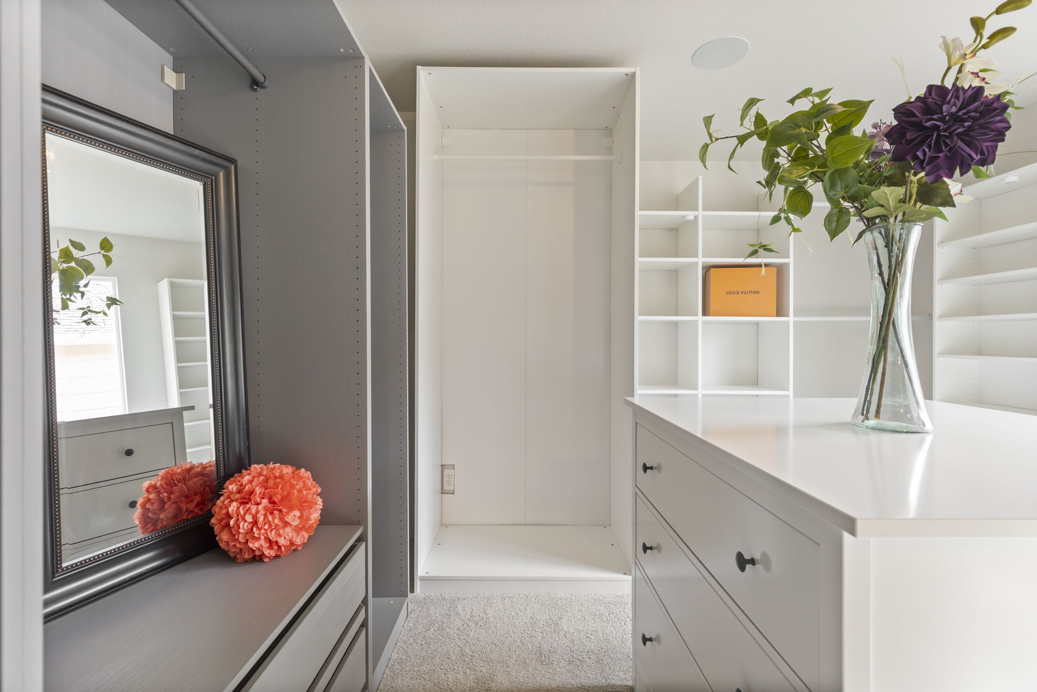 Custom double walk-in closet featuring built-in drawers, shelving, and hanging space.