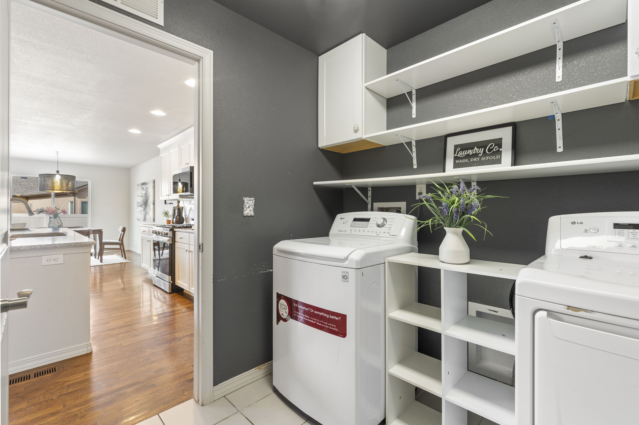 Main-level laundry room with built-in shelving, washer and dryer