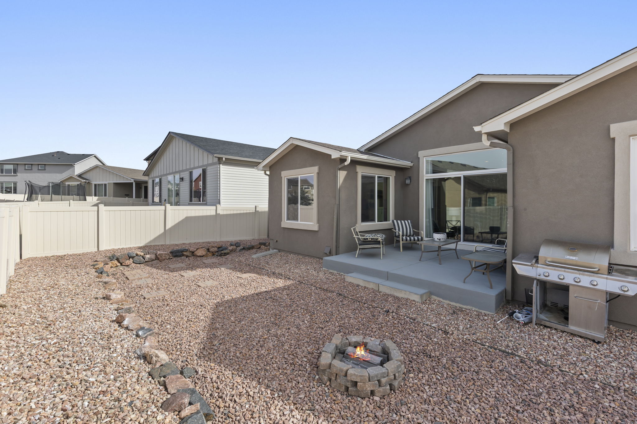 Fenced backyard featuring a patio area and a fire pit