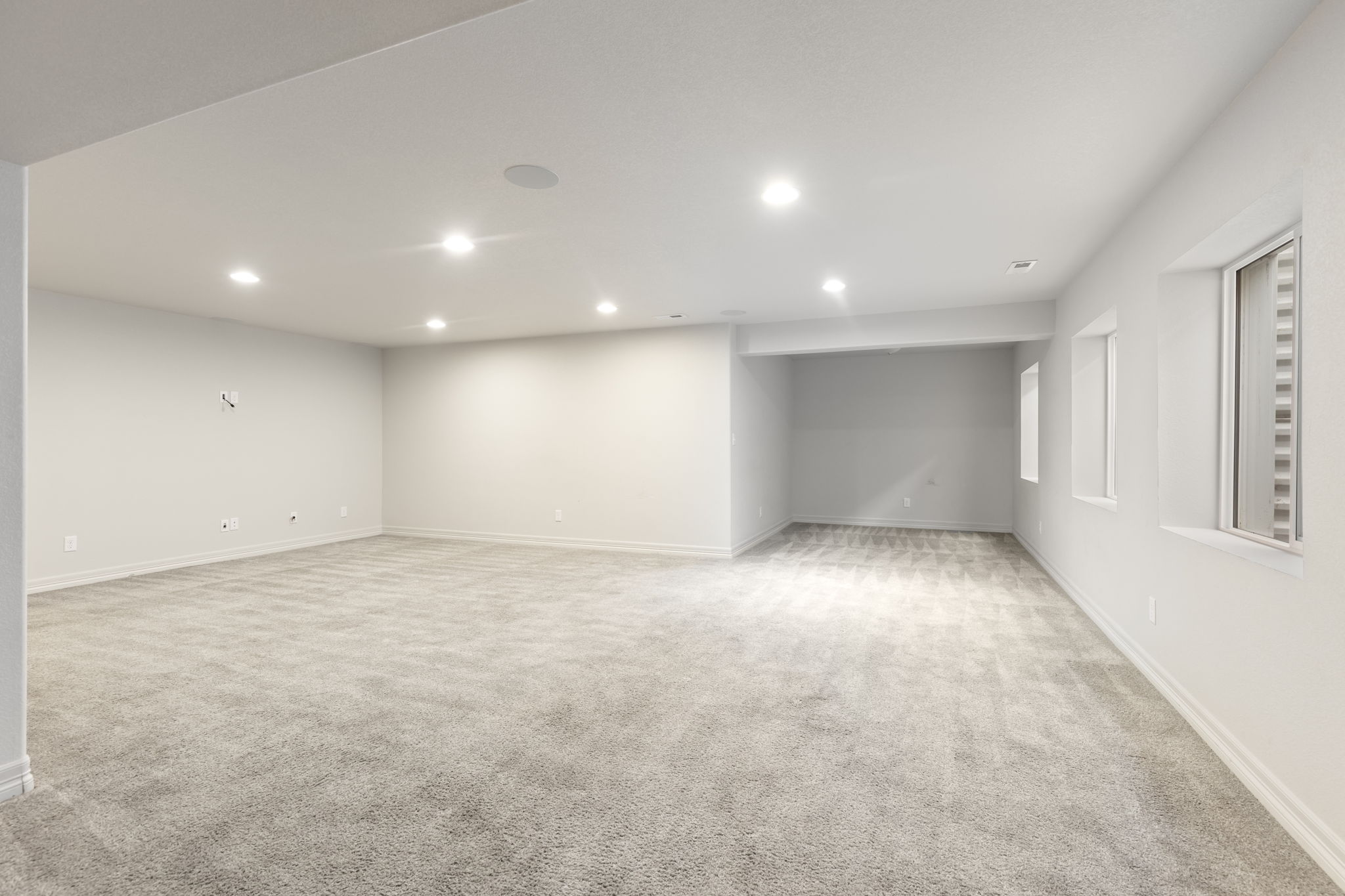Spacious finished basement recreation room with recessed lighting and flexible open layout.