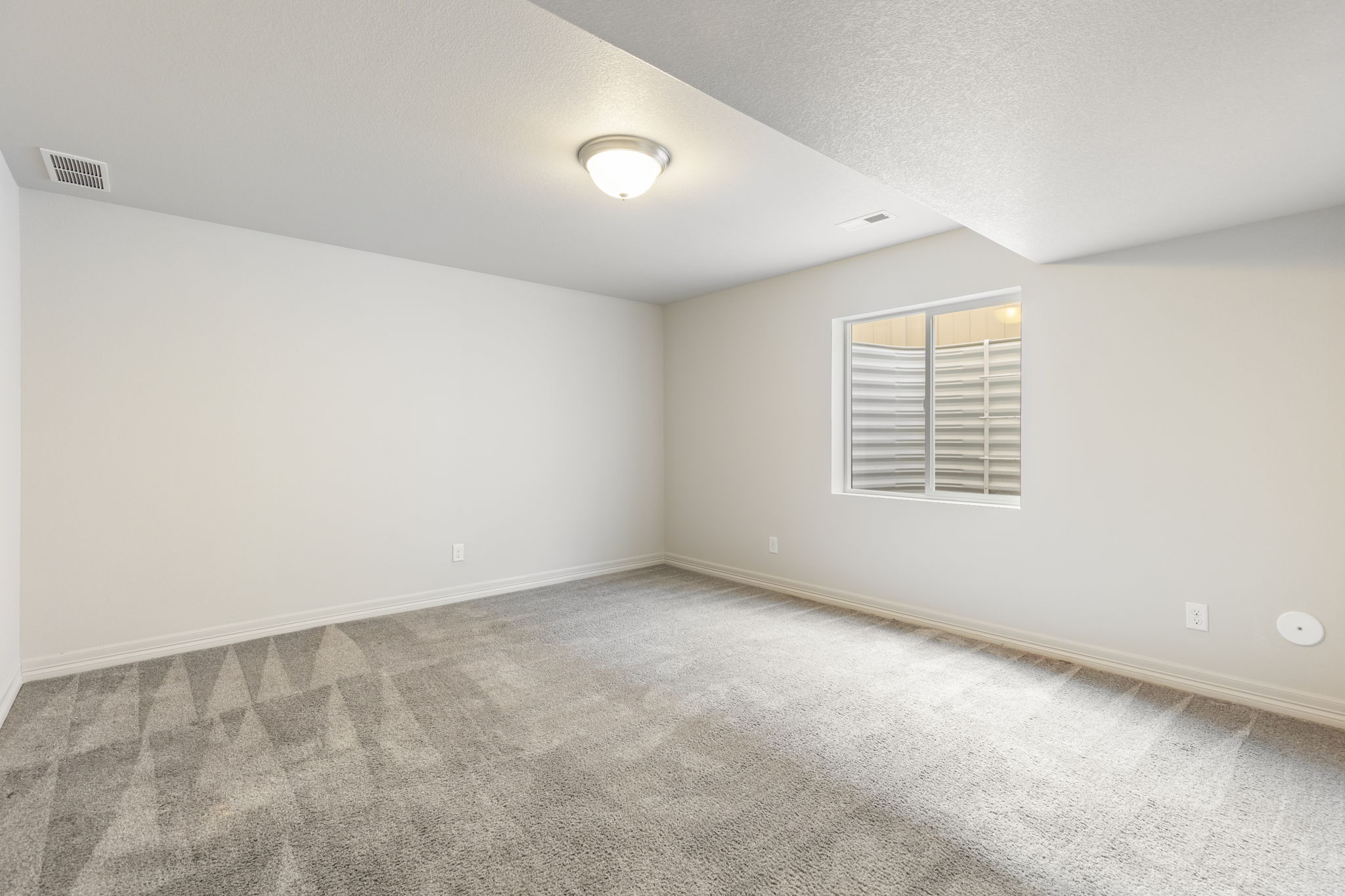 Finished basement bedroom with carpeted flooring, recessed lighting, and egress window