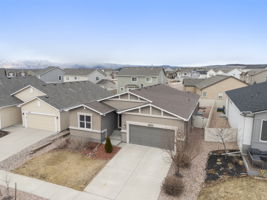 Front exterior aerial of 2016-built stucco ranch with attached 2-car garage and concrete driveway.