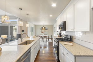 Kitchen view highlighting gas range, stone countertops, and extended counter space for food prep and entertaining.