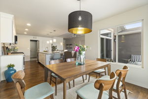Dining space connected to the kitchen, showcasing hardwood floors and open sightlines.