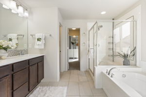 Primary bathroom featuring a soaking tub, walk-in shower with glass enclosure, and tile flooring.