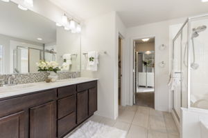 Primary bathroom featuring a soaking tub, walk-in shower with glass enclosure, and tile flooring.