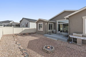 Fenced backyard featuring a patio area and a fire pit