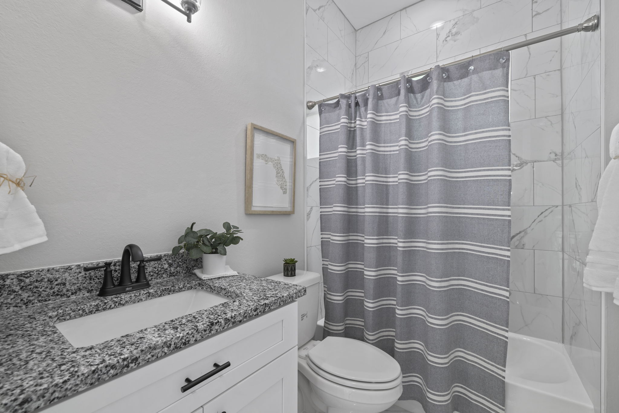 Guest bathroom - granite countertop and tub shower