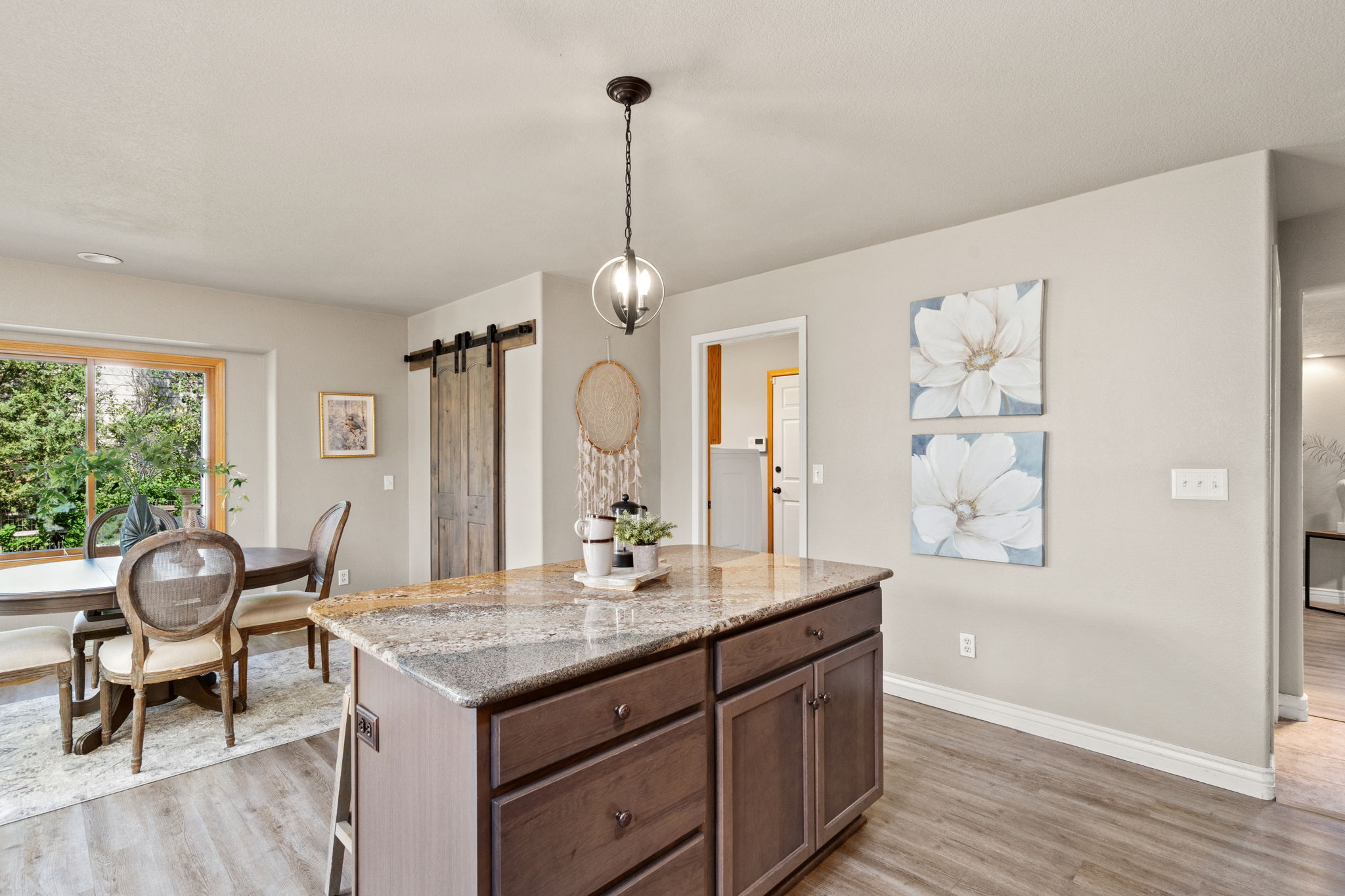 Notice the walk-in pantry with stylish barn doors and the convenient access to main level laundry room and 3 car garage.