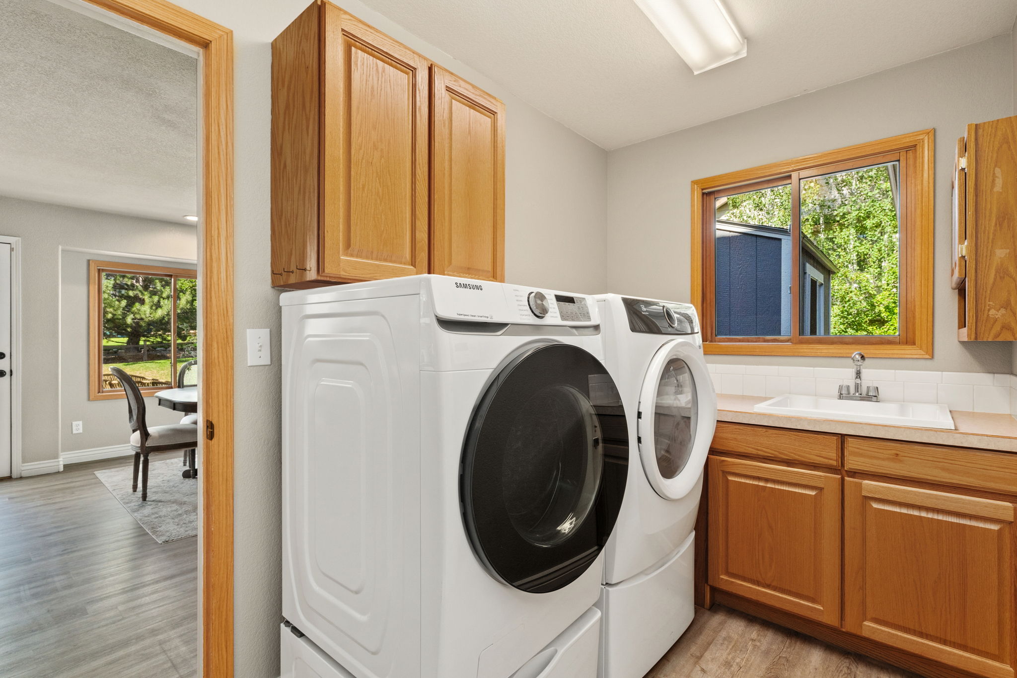 Laundry room/mud room with utility sink sits between the 3 car garage and the kitchen. Washer and dryer included.