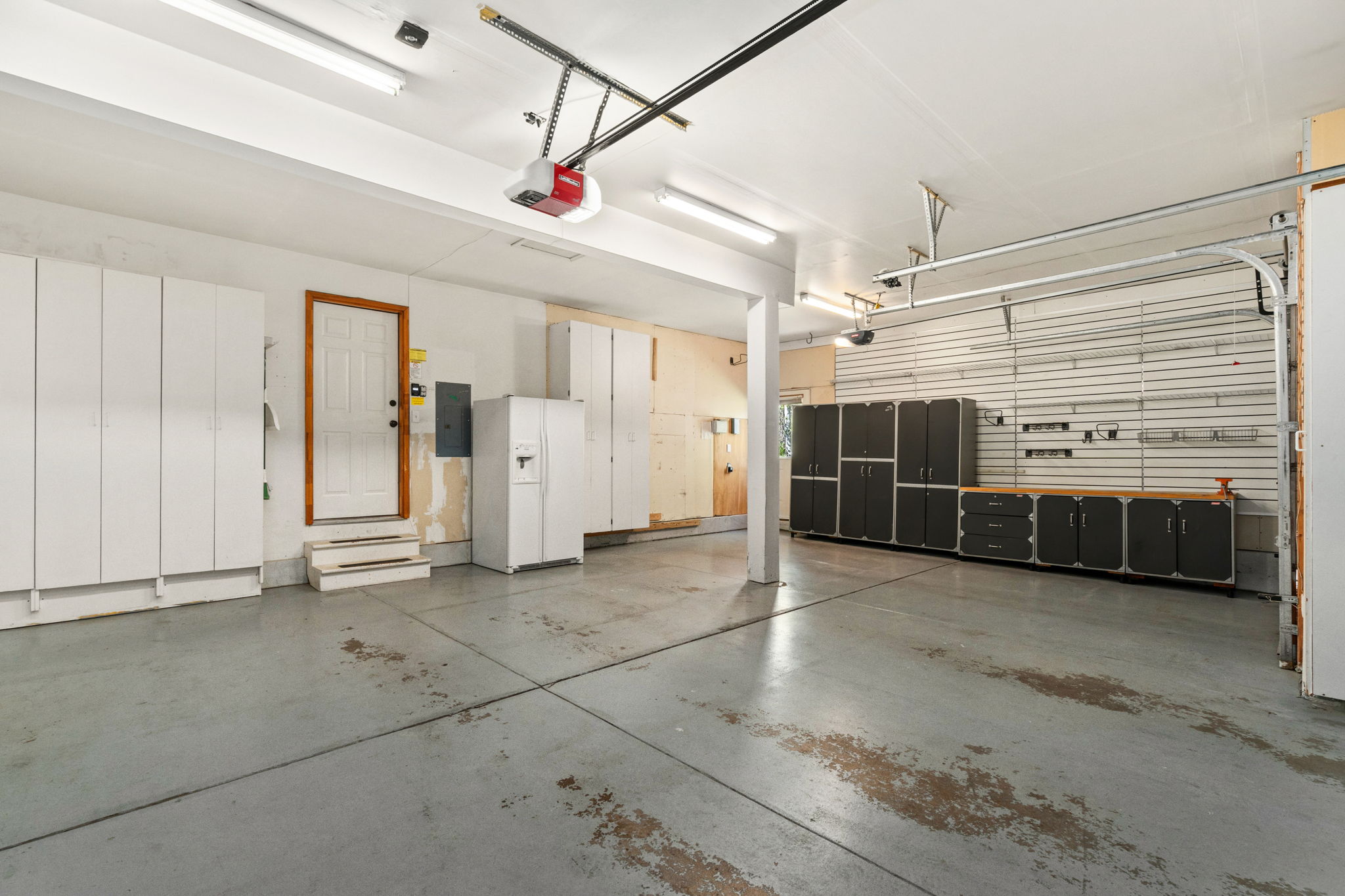 Three car attached garage with backyard access, storage galore, and a garage refrigerator - all included!