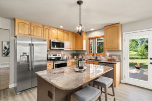 The eat-in kitchen is the heart of the home...new appliances, large island, granite countertops, and walk-in pantry.