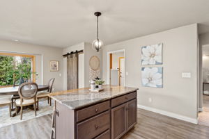 Notice the walk-in pantry with stylish barn doors and the convenient access to main level laundry room and 3 car garage.