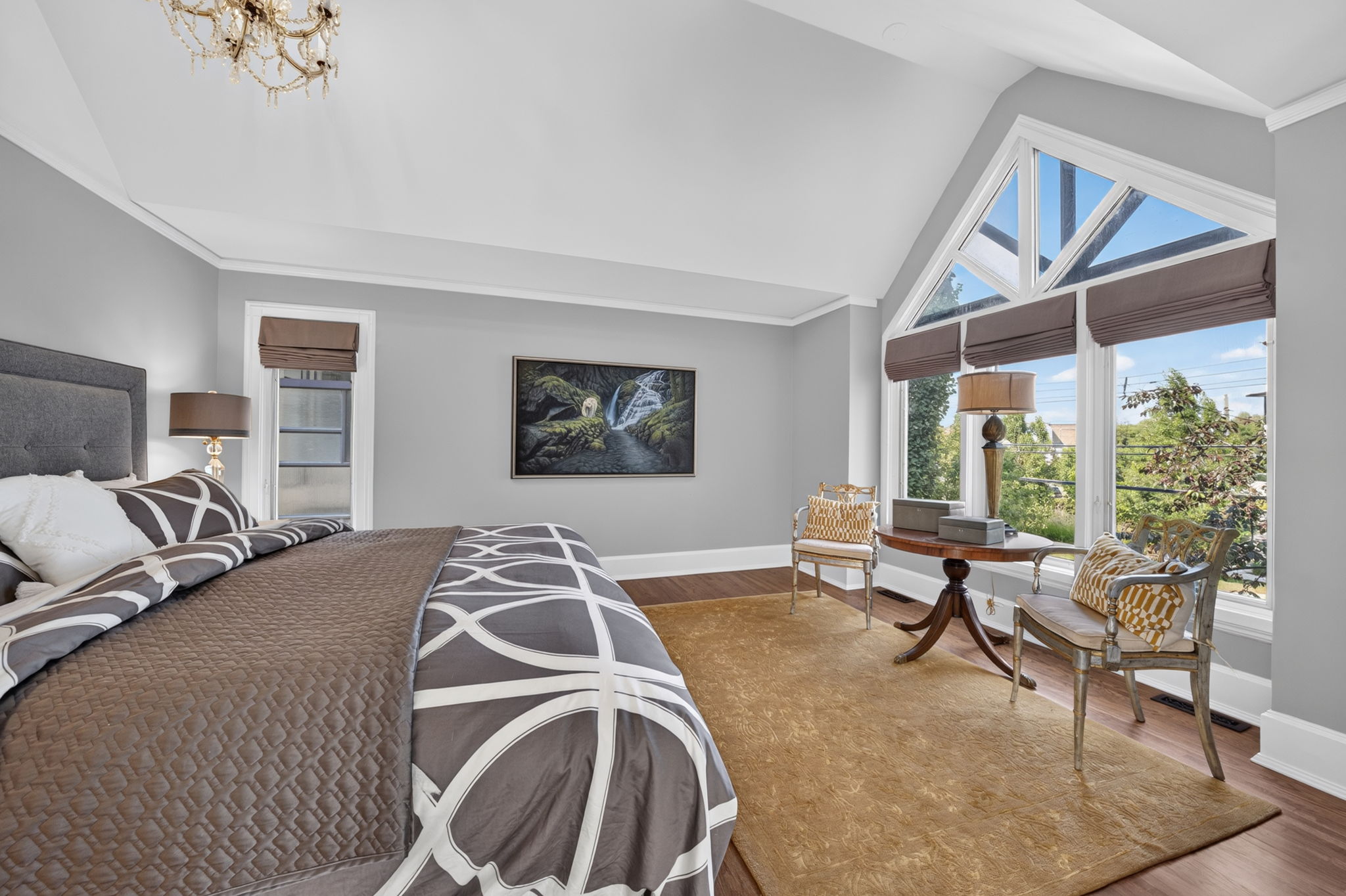 Vaulted primary retreat with a dramatic arched window