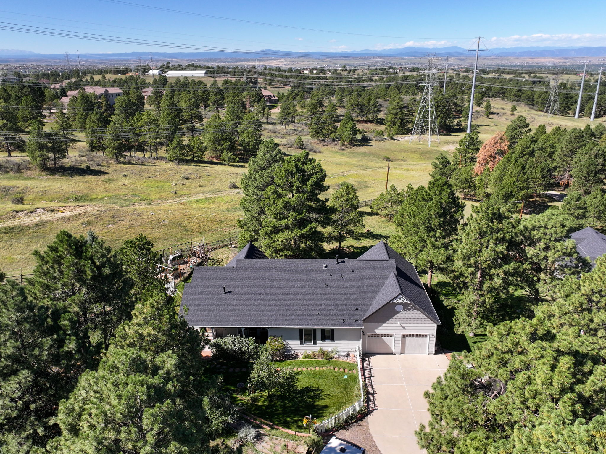Great view of the back of the home, complete with a 4 car tandem garage and a white picket fenced backyard.