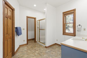 Primary en suite bathroom with large walk in closet.