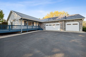 Low maintenance blacktop driveway, metal siding & attractive garage stone accents