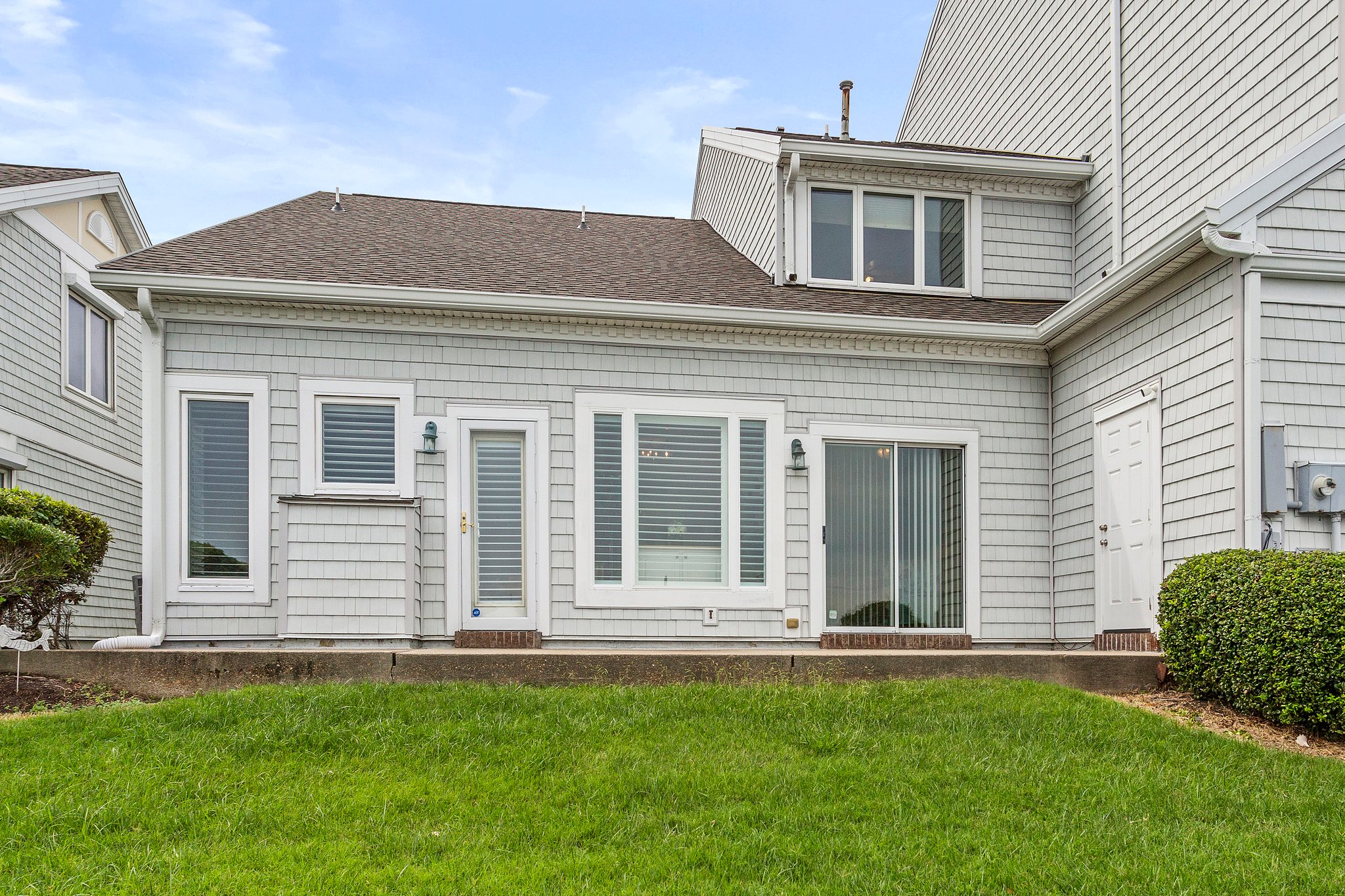 Large patio with storage and grassy area, ideal for enjoying water views and peaceful outdoor moments