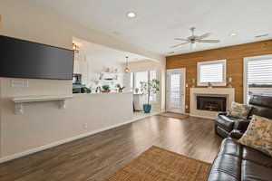 Open-concept living space flowing seamlessly into the kitchen, featuring a cozy gas fireplace