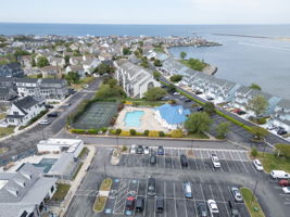 Aerial photo highlights the beautiful area, featuring the clubhouse, pool, and tennis courts