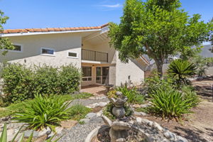 Beautiful side garden with private patio access and covered balcony.