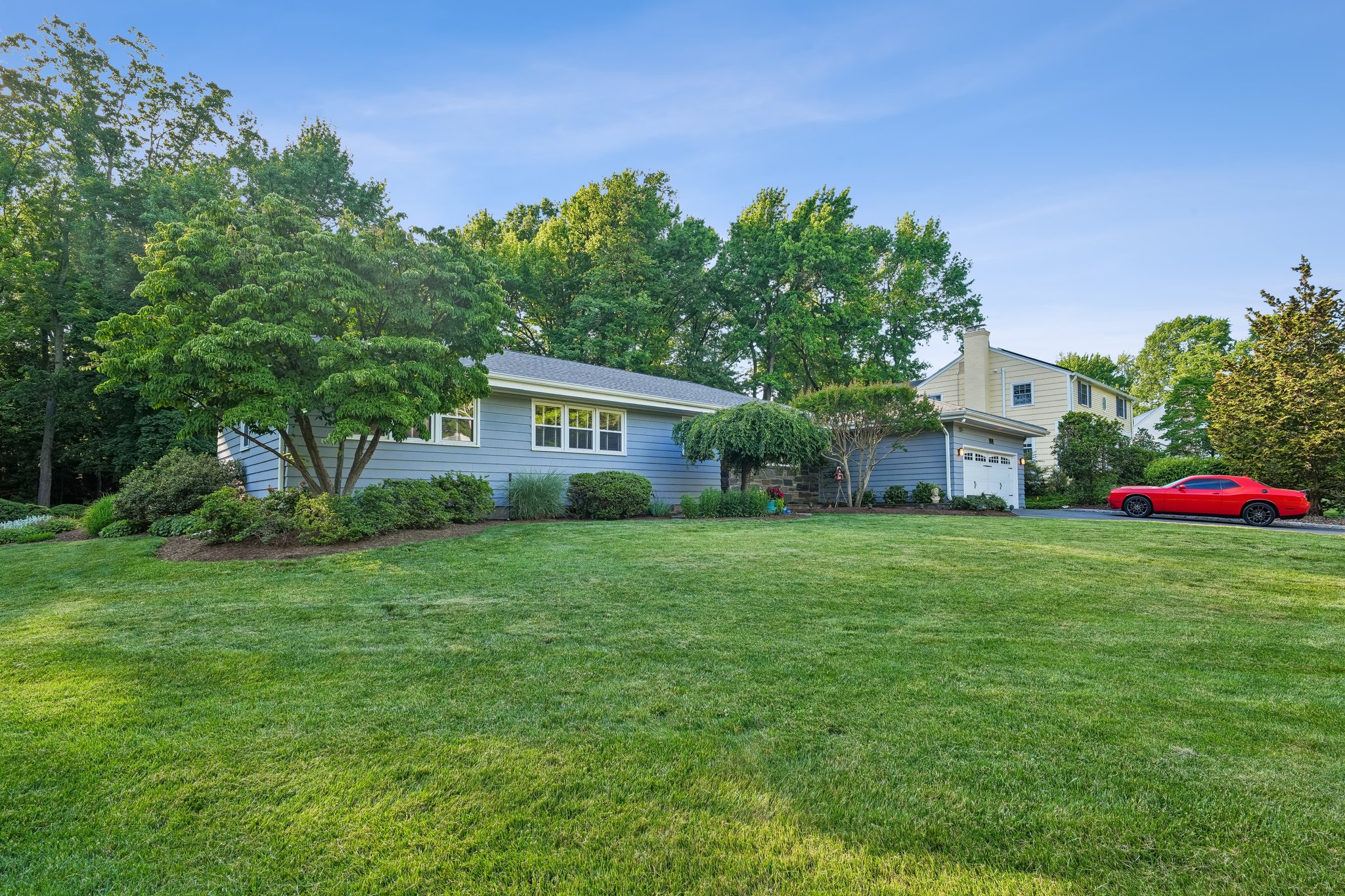 Gracefully positioned on its oversized lot, the home enjoys a rare sense of breathing room. Mature plantings, sweeping lawns, and neighboring parkland create a feeling of tranquility from the moment you arrive.
