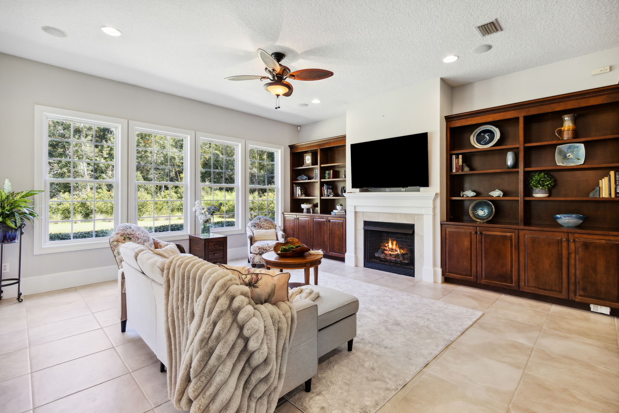 ...with surround sound and a cozy gas fireplace, flanked by custom built-in cabinets