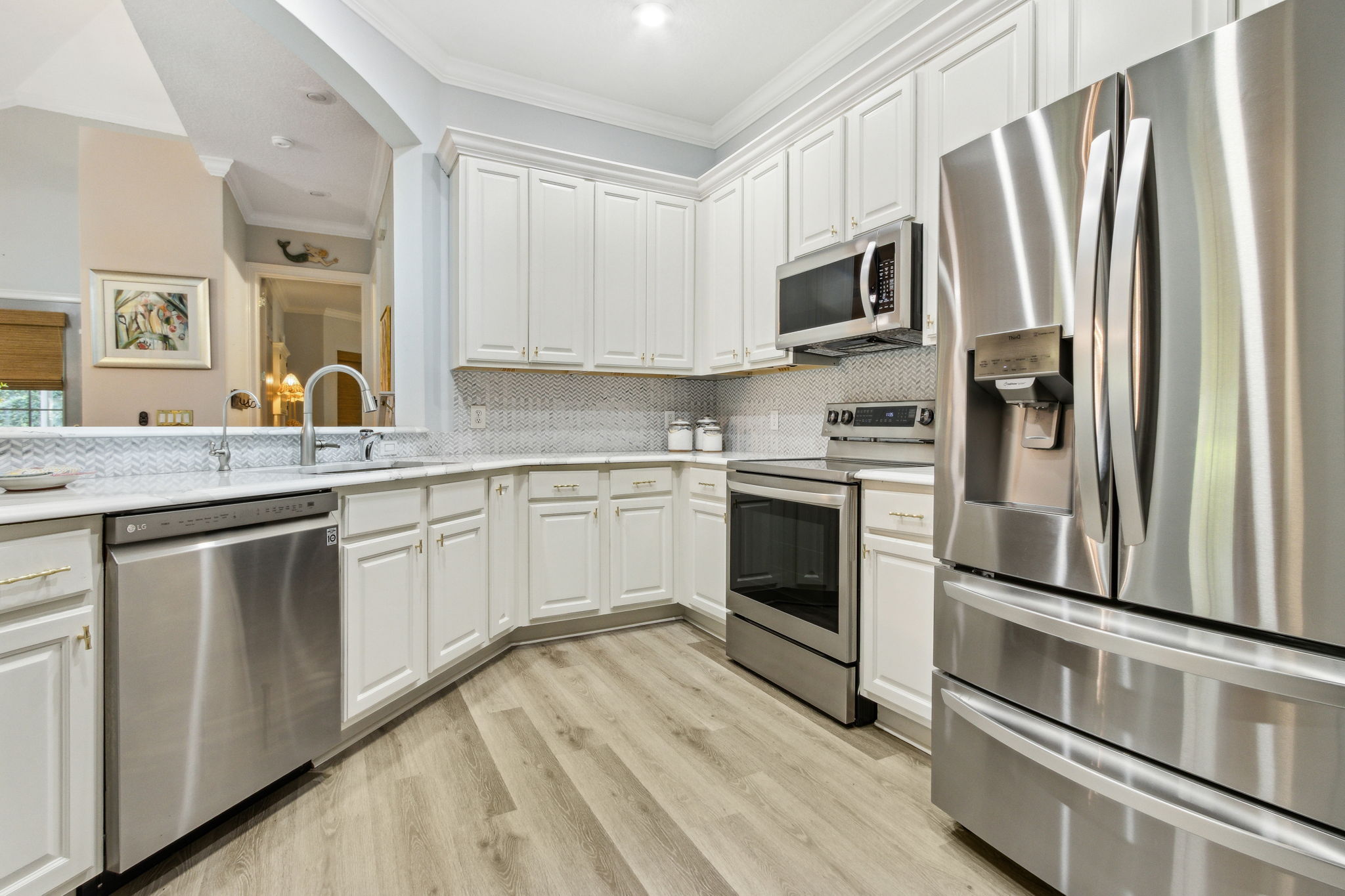 In the renovated kitchen, softly veined quartz counters ...