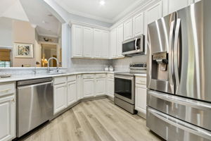 In the renovated kitchen, softly veined quartz counters ...