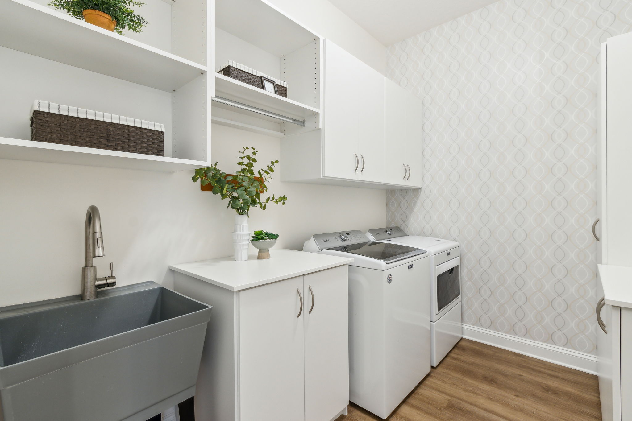 ...even the laundry room is pretty, yet functional with utility sink and additional cabinet storage.