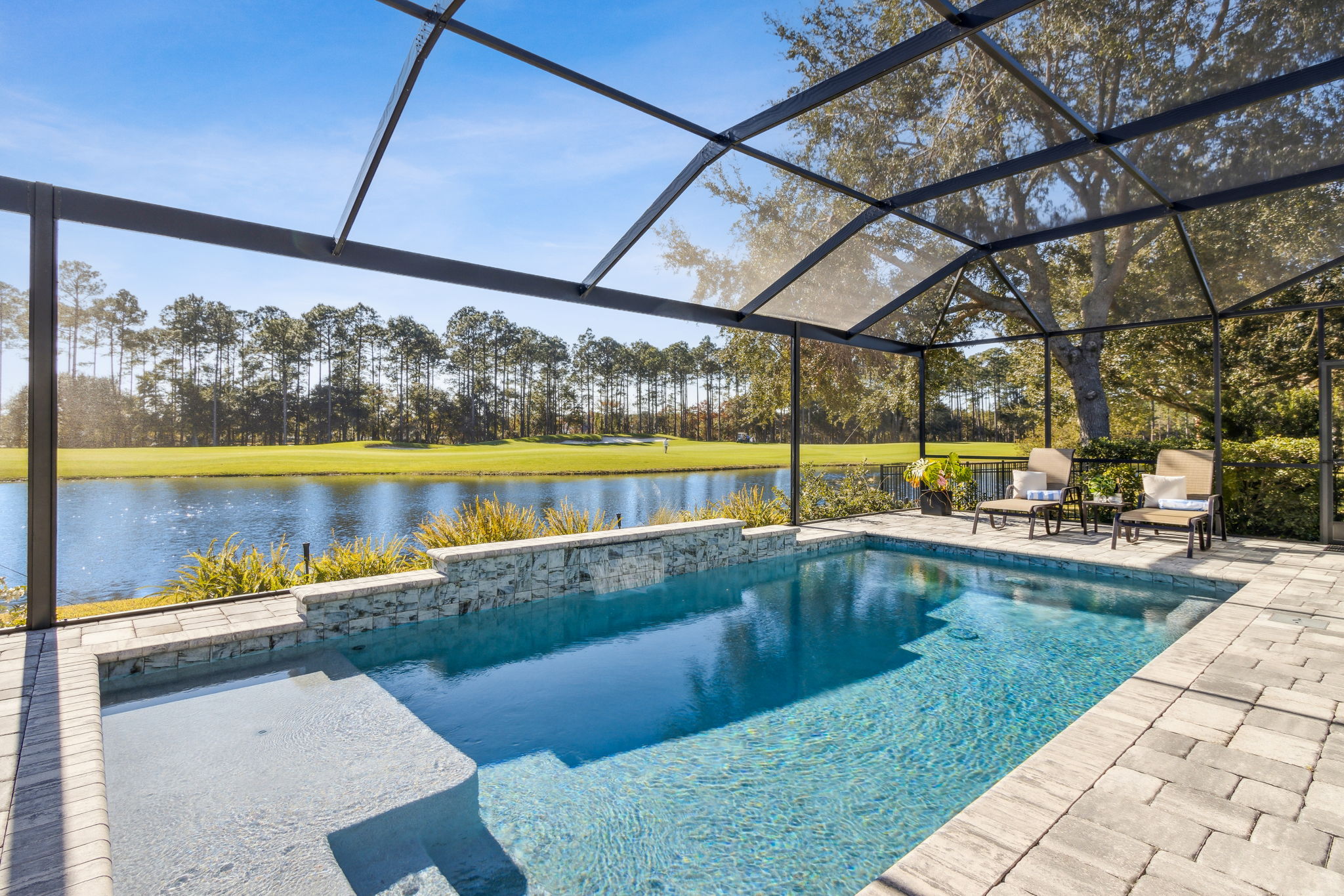 The screened pool is salt water and features a tranquil waterfall feature.