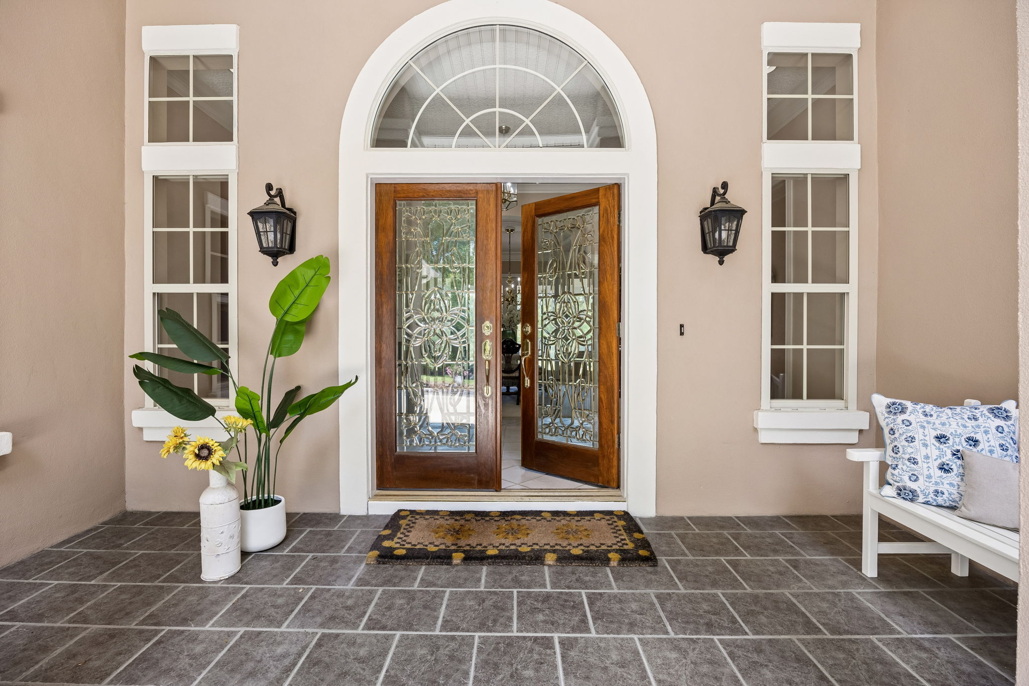 Double doors, arched glass, and classic symmetry create a sense of arrival before you ever step inside…