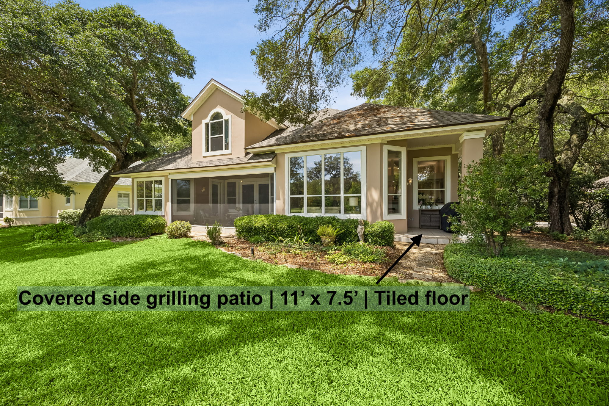 Behind the home, outdoor living continues with a covered side grilling patio tucked just off the main spaces.