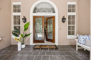Double doors, arched glass, and classic symmetry create a sense of arrival before you ever step inside…