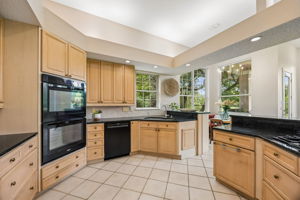 In the kitchen, double ovens, instant hot water, generous cabinetry, and view-facing prep spaces make daily living feel elevated.