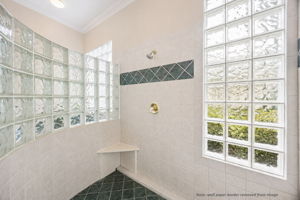 The walk-in shower is filled with soft filtered light, adding a bright, airy feel to the suite.