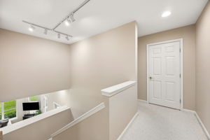 The open stairwell leads to the second-floor guest suites, creating a natural separation from the first-floor primary retreat.