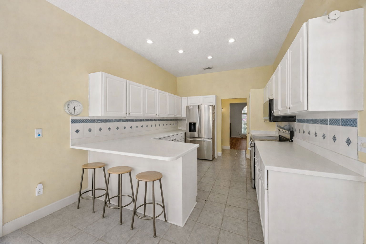 The layout flows easily into the kitchen, with generous cabinetry, Corian countertops, new LG stainless appliances, and an open connection to the living areas for easy everyday flow.