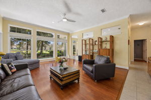 From the foyer, the home opens into a spacious main living area where wraparound windows, abundant natural light, and Karndean Van Gogh luxury vinyl plank floors bring warmth and a bright, welcoming feel.