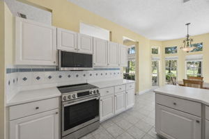 Just beyond, the breakfast area is surrounded by windows and positioned to enjoy the backyard and golf course setting.